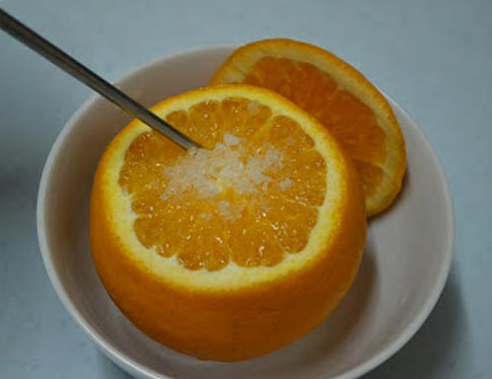 Dùng đũa chọc làm sao cho muối vào được trong giữa trái cam là được!
